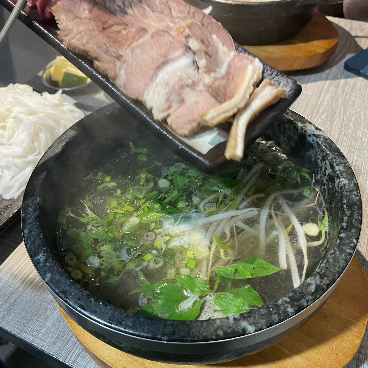特越 PHỞ 的餐點圖片：店員會幫忙把生牛肉加入石鍋裡 由乃子過日子 拍攝