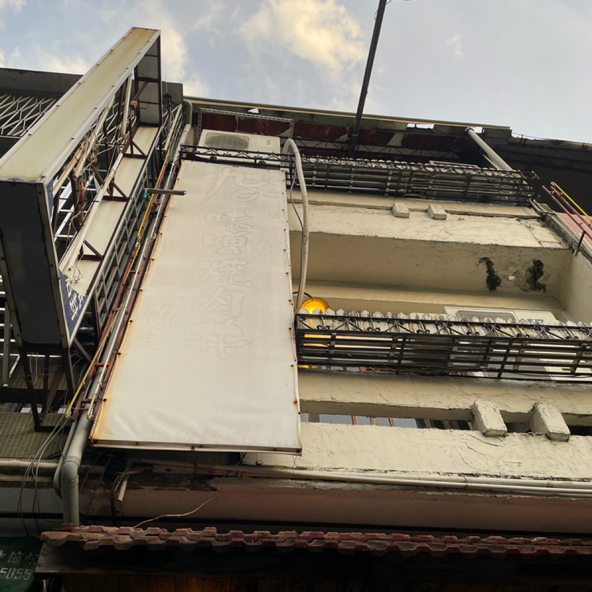 Vibe image of 九日味噌燒肉丼專門店: 這是店招牌，
這張照片是站在店門口往上拍的視角。

從車道看的那面已經破得乾乾淨淨了～
（就是左邊那 shot by 一刻又一嗑