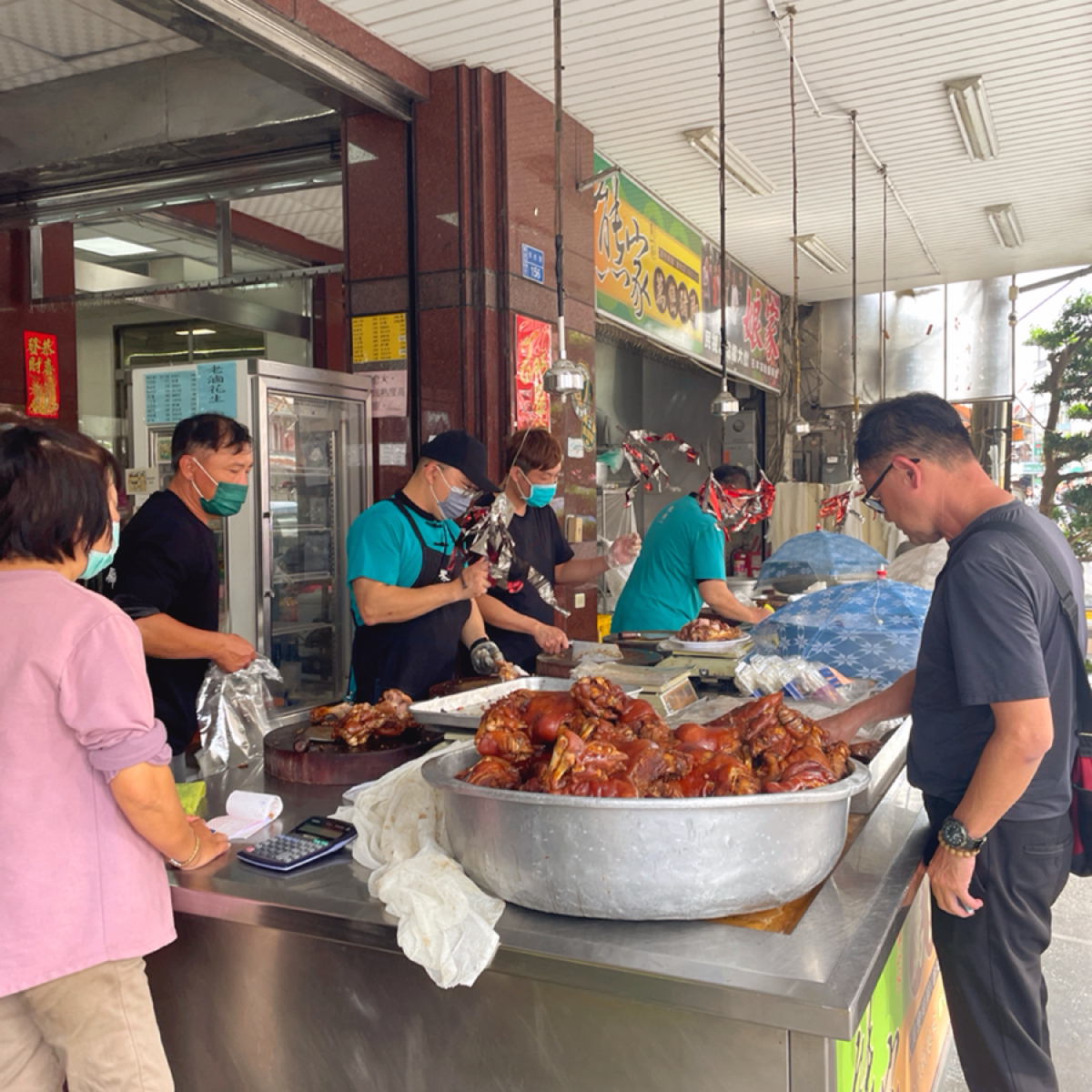 Vibe image of 熊家萬巒豬腳: 門口的店員是豬腳處理專門流水線。

豬腳也有冷凍的可以買，但個人覺得冷凍略失風味，現場買+回家快速吃 shot by 一刻又一嗑
