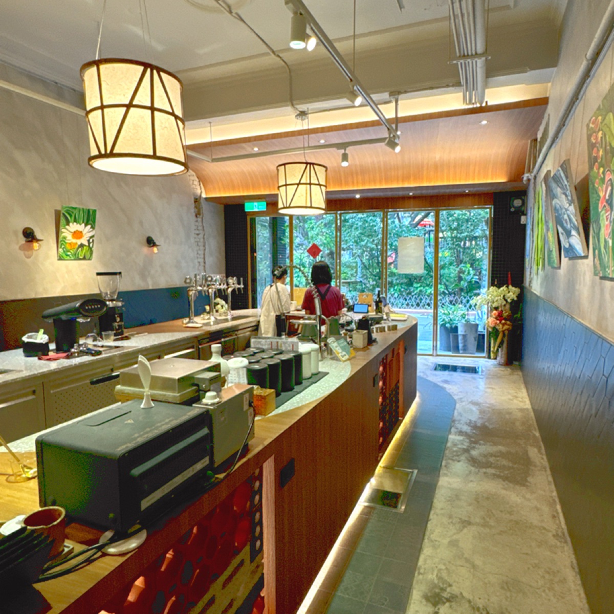 Vibe image of Wangtea Lab: 一樓空間挑高、中島為茶飲的調製區，最近還有藝術家的畫展，周圍擺上畫作 shot by Ana